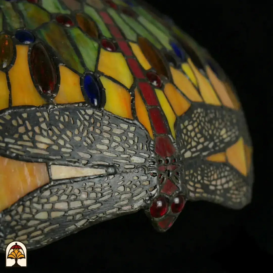 Close-up onverlichte libellenmotief langs rand kap Libellula Aurelia ⌀50, gele panelen, grijze libellenvleugels met rode juwelen en rode glasaccenten