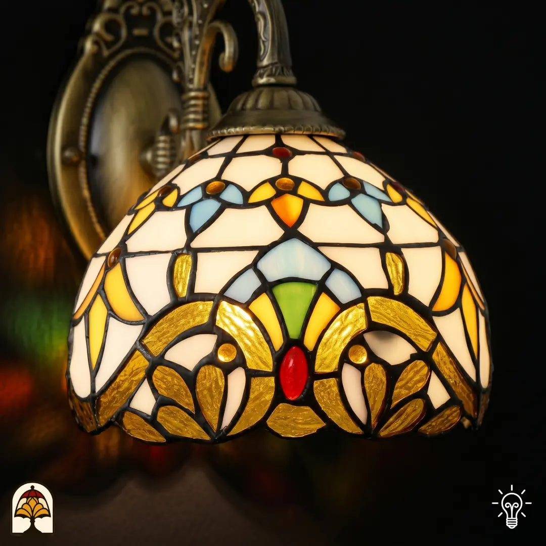 Close-up van de barokke Tiffany kap met goudgele bladvormen, blauwe vlakken, groene accenten en rode ovale steen in glas-in-lood
