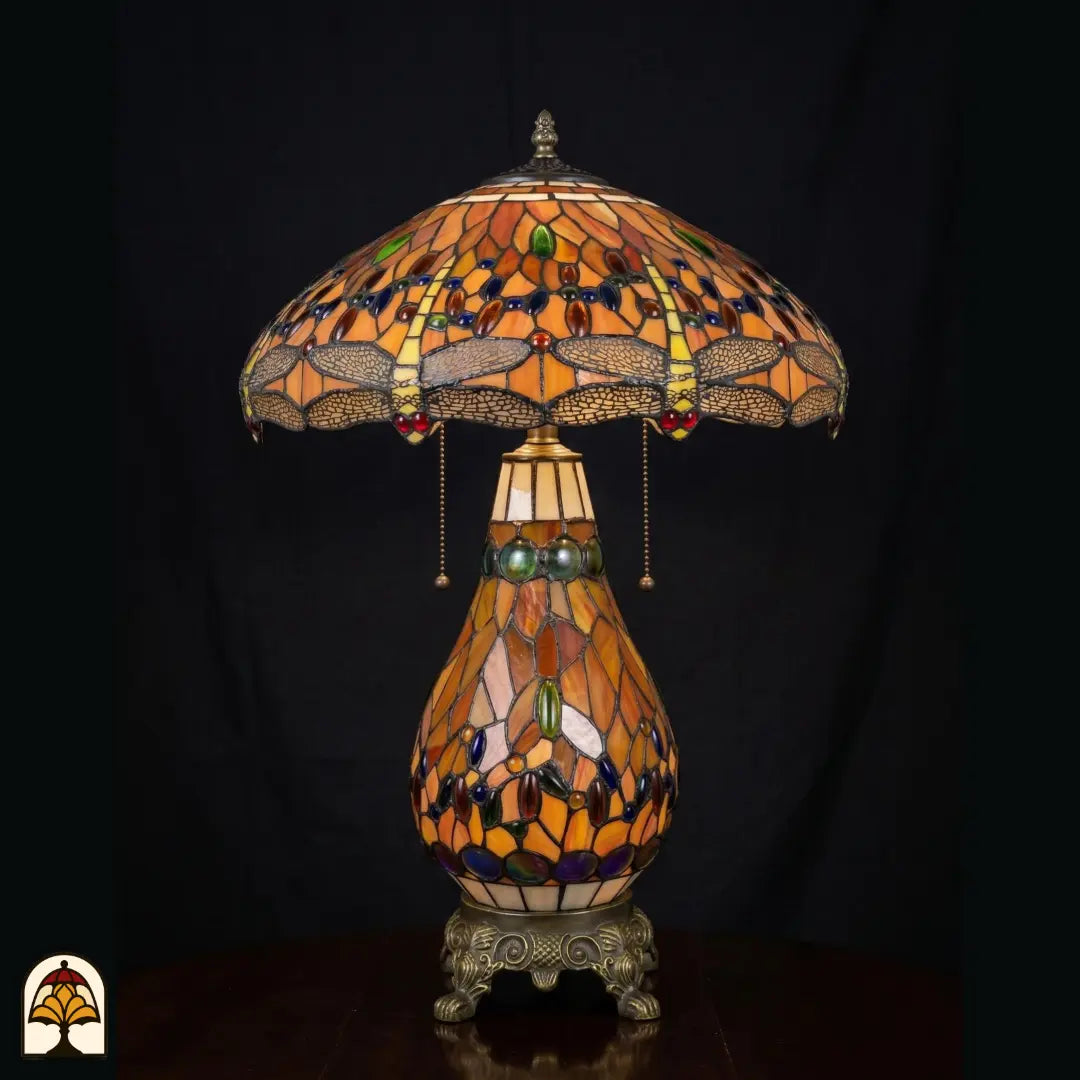 Tiffany lamp tafellamp onverlicht, koepelvormige kap met libellemotieven langs de rand en amberkleurig glas, blauw en groen-amber glaskralen, glas-in-lood peervormige voet en bronzen leeuwenpootvoet