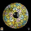 Bovenaanzicht verlichte koepelkap Tiffany tafellamp Sylva Verde, geel-groene, lichtblauwe, roze en oranje bladmotieven in glas-in-lood, centrale bronzen fitting zichtbaar