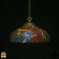 Tiffany lamp hanglamp onverlicht in donkere omgeving, koepelvorm met rode poinsettia-bloemen, blauwe madeliefjes, wit-lavendel vlinder en gele bladpanelen, bronzen gekartelde onderkant, opgehangen aan bronzen ketting