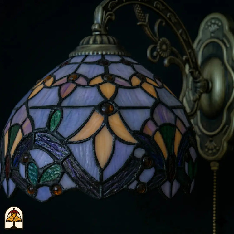 Onverlichte kap Tiffany wandlamp Royal Mosaic close-up – lavendelblauw, oranje en groen glas-in-lood met paarse iris en donkere loodlijnen