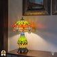 Verlichte Tiffany tafellamp Libellula Lumina ⌀30 cm in interieur – oranje en geel-groene glas-in-lood kap met libellenmotief, bronzen leeuwenpootvoet, warm licht