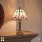 Tiffany tafellamp Rosa Zaffiro in interieur verlicht – klassieke sfeer op houten tafel