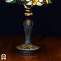 Close-up voet — bronzen klassieke kandelaarvoet met bladvormige decoraties en geribbelde ronde basis op houten oppervlak