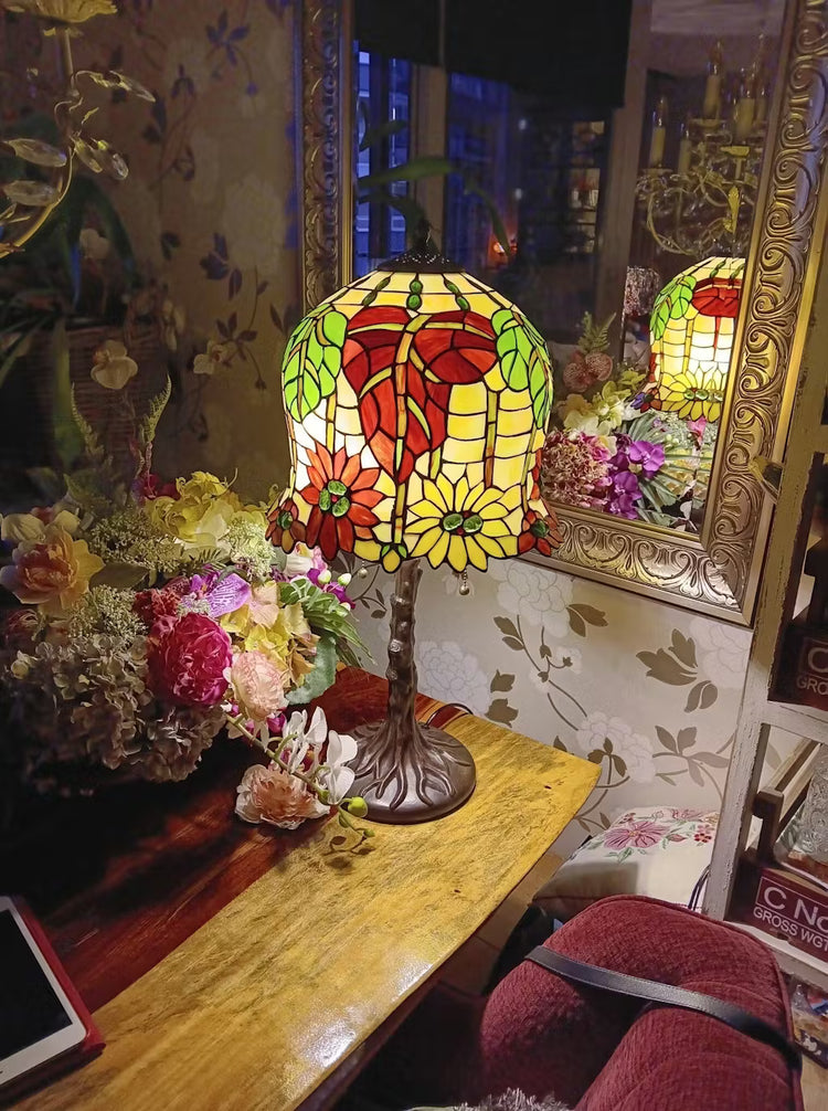 Tiffany tafellamp met herfstbladeren en geel glas-in-lood, warm en sfeervol licht passend bij een klassiek interieur.