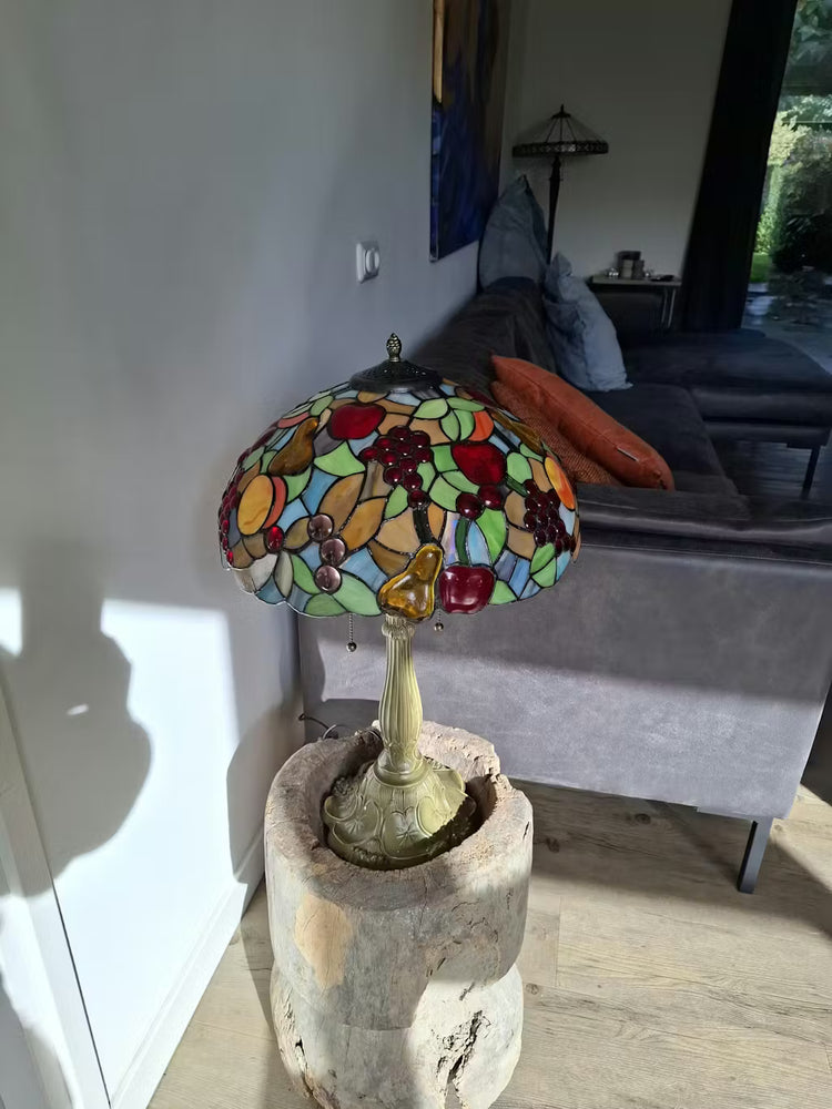 Tiffany tafellamp glazen kap met peren en druiven, warm en sfeervol licht voor een klassiek interieur.