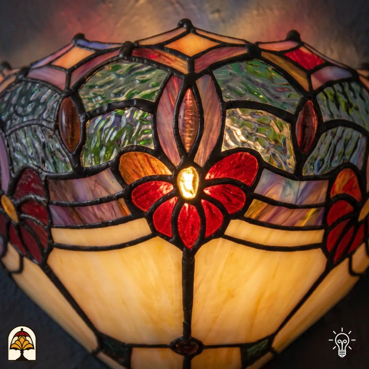 Tiffany wandlamp Giglio Rubino in interieur – warm rood-geel lichtspel op muur