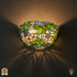 Tiffany wandlamp Rosa di Primavera verlicht op muur – roze bloemen en groene bladeren in glas-in-lood